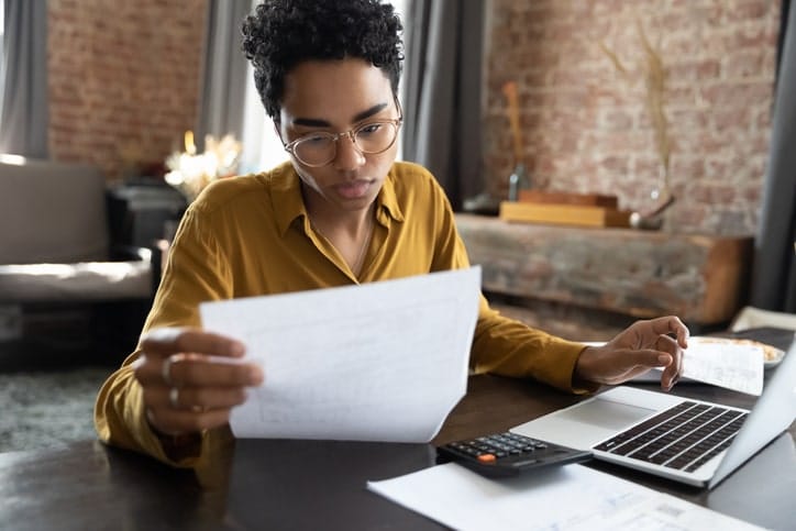 Woman looks over documents as she builds her budget.